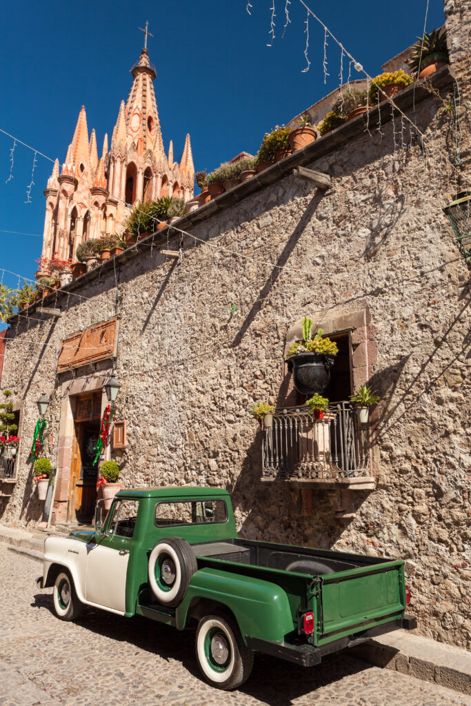 old pickup on the street in san miguel de allende with cathedral in background